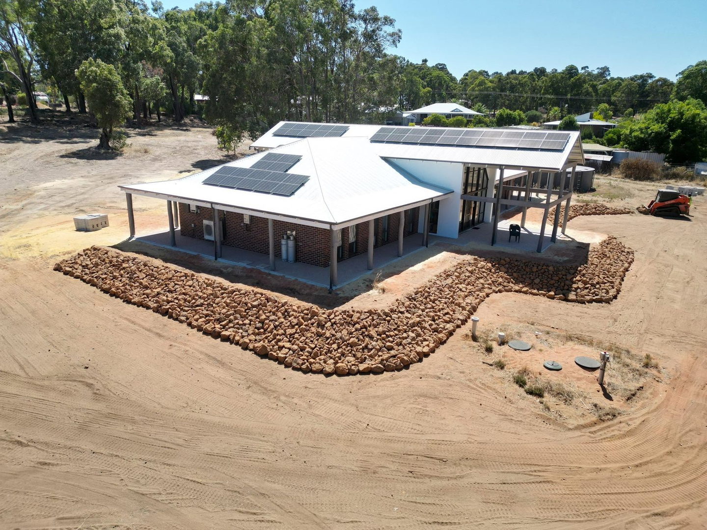 Aerial view of a finished house pad with rock edging, level and ready to build on